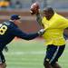Former Michigan football player Geoffrey Steger pulls Geraold White's jersey during the annual alumni flag football game before spring practice at Michigan Stadium on Saturday, April 13, 2013. Melanie Maxwell I AnnArbor.com